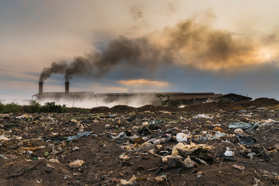 Garbage in front of smoking chimneys